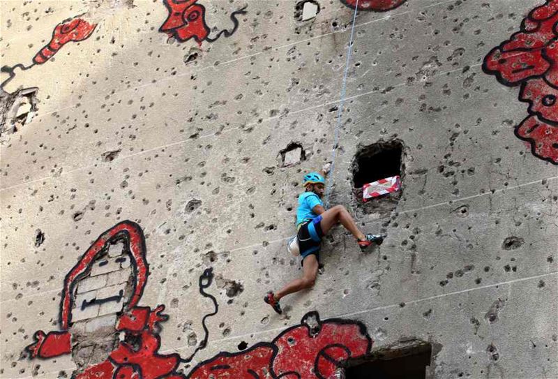 A competitor climbing the hole-ridden facade of Beirut’s al-Kamal building, during an urban climbing contest.