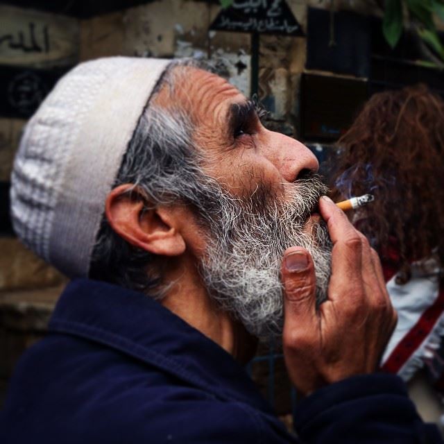 A Lebanese man smoking in front of oriental public bath, Tripoli, Lebanon,...