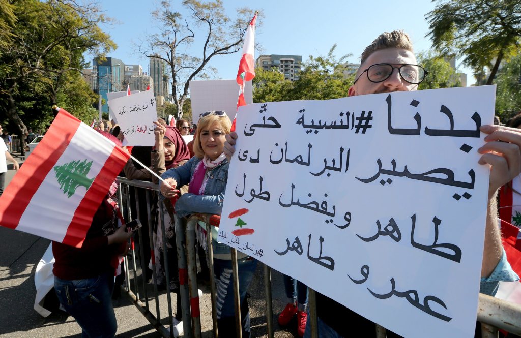 Lebanese demonstrators carry placards reading ‘We need an election at proportion law’, in Beirut. (NABIL MOUNZER / EPA)