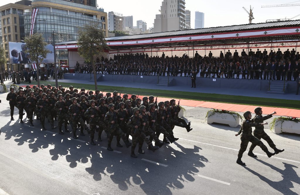 Lebanese police members man machine guns from a armoured personnel carrier (APC) as it drives down a military parade during the 73rd independence day celebration.