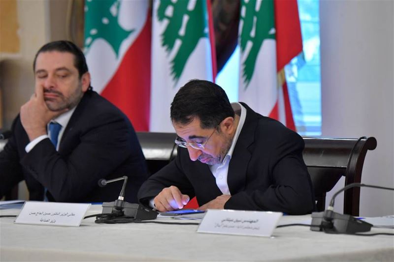 PM Saad Hariri taking a glance toward minister Hussein Hajj Hassan, as he looks busy working on his mobile phone, inside the grand Serail in Beirut, Lebanon. (Nabil Ismail)