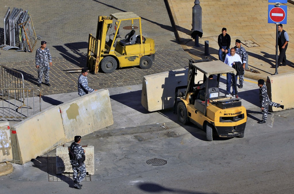 Policemen remove concrete barriers to open a road leading to the parliament building after being closed from almost 2 year.